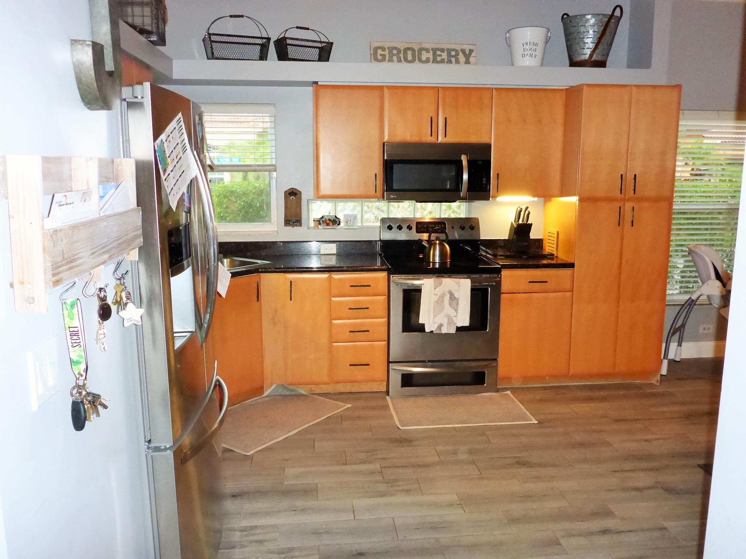 5009 Elpine Way Riviera Beach, FL 33418 - Photo 20 of 41 a kitchen with stainless steel appliances a stove top oven a sink and a refrigerator