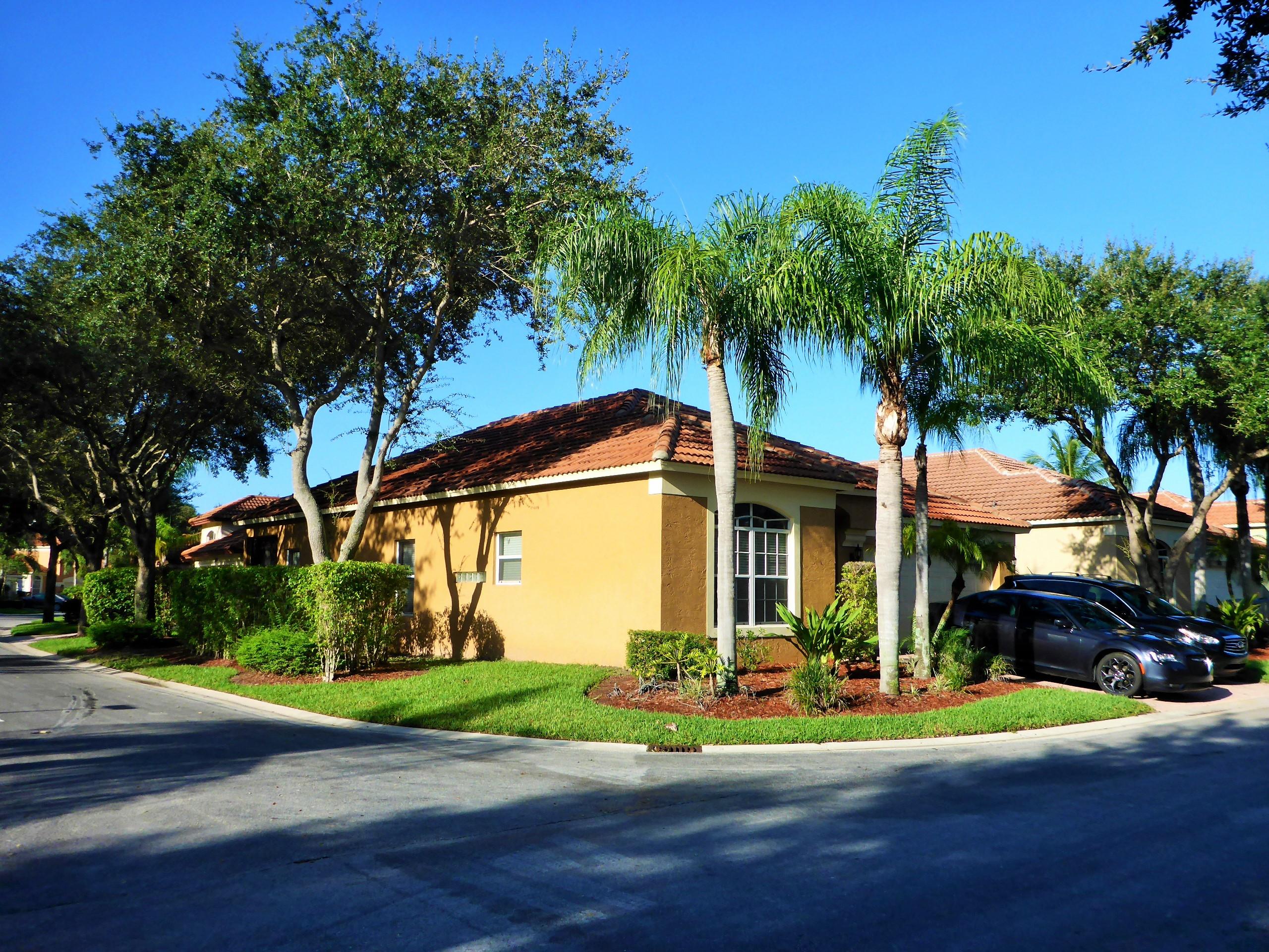 5009 Elpine Way Riviera Beach, FL 33418 - Photo 40 of 41 a front view of a house with a yard and potted plants