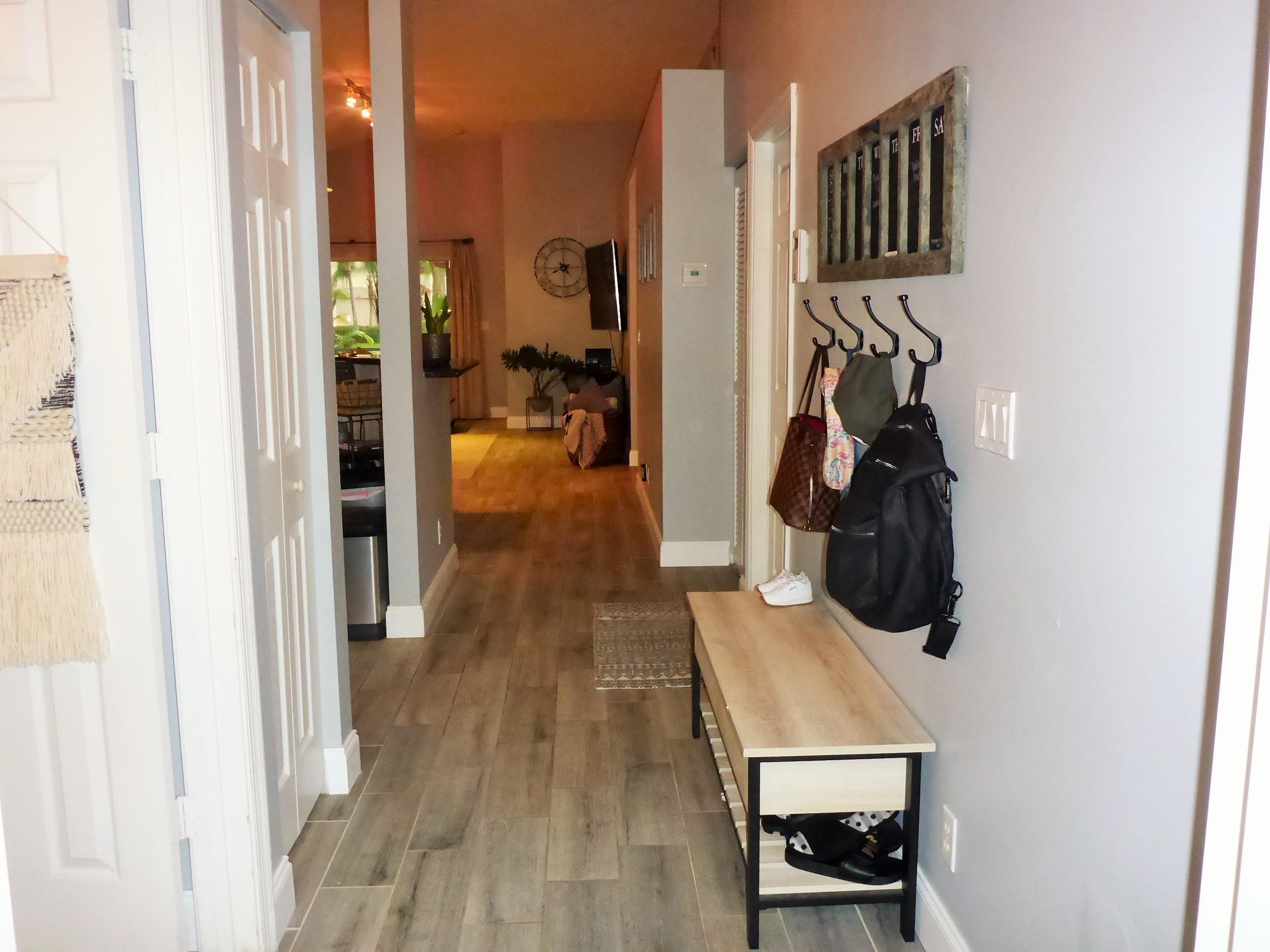 5009 Elpine Way Riviera Beach, FL 33418 - Photo 4 of 41 a view of a hallway with a white walls and a wooden floor