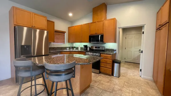 a kitchen with stainless steel appliances granite countertop a stove a sink and a refrigerator