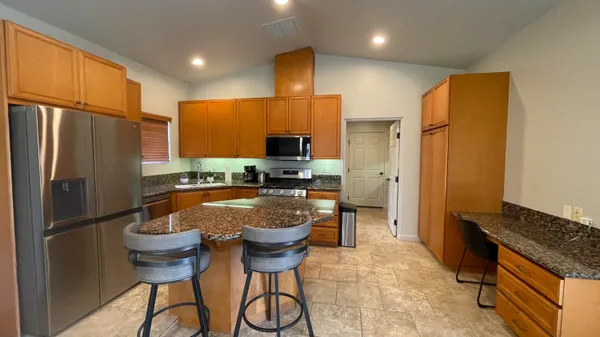 a kitchen with stainless steel appliances granite countertop a refrigerator and a stove top oven
