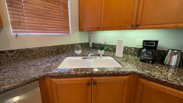 a kitchen with granite countertop a sink a stove and cabinets