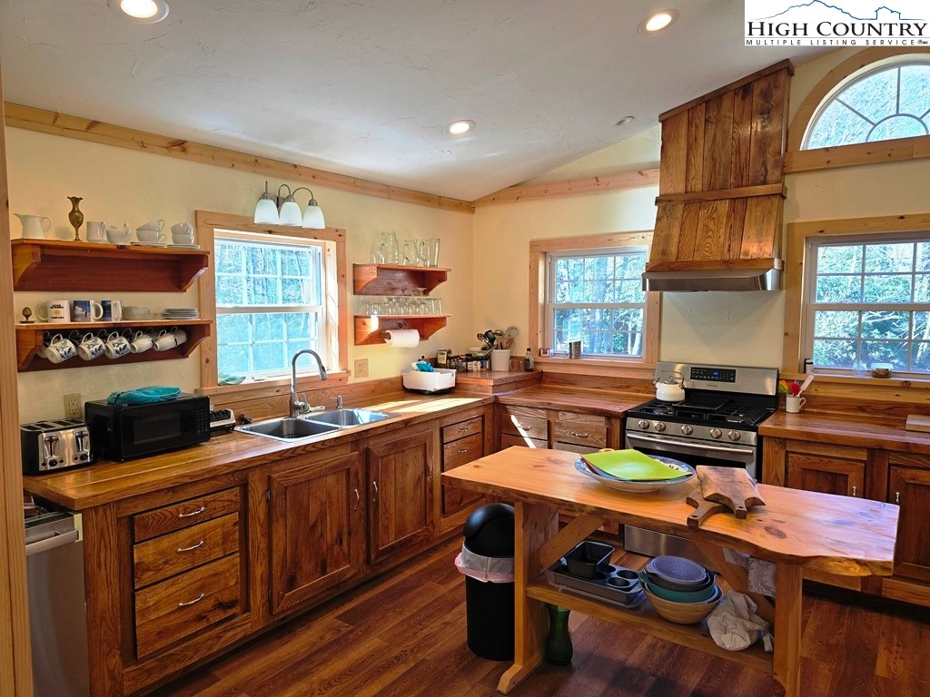 115 Little Horse Path Lansing, NC 28643 - Photo 12 of 33 a kitchen with a stove a sink dishwasher and cabinets with wooden floor
