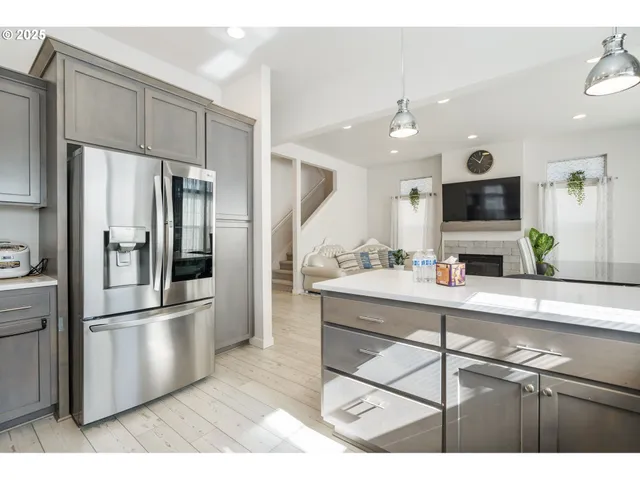 a kitchen with kitchen island a counter top space stainless steel appliances and cabinets