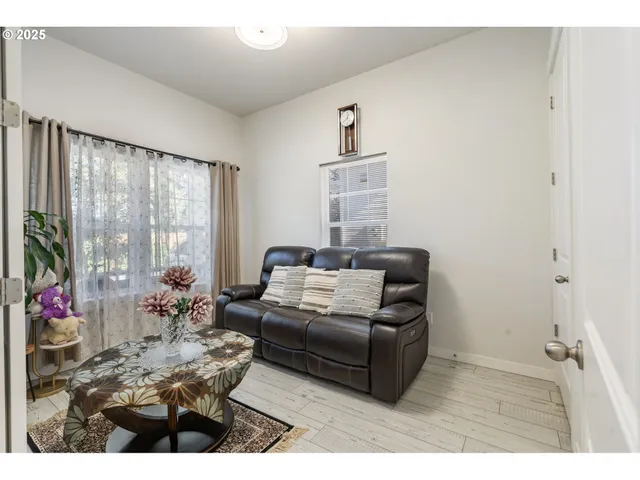 a living room with furniture flowerpot and wooden floor