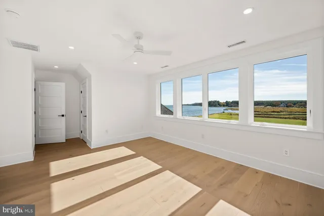 a view of a lake with lawn chairs under an umbrella