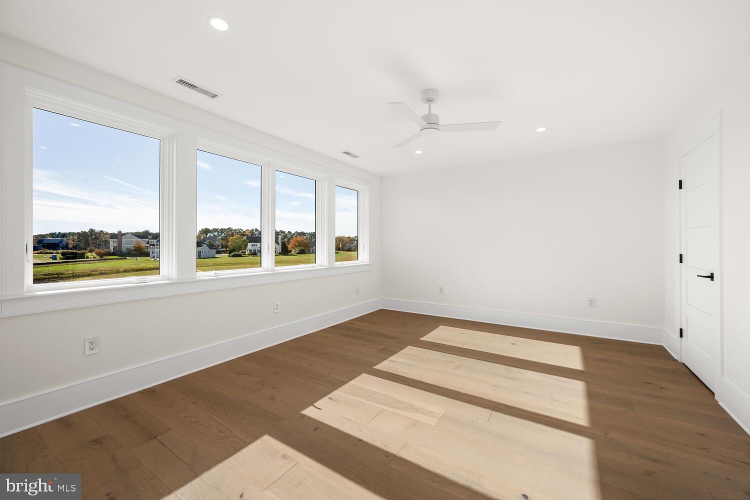 21485 Island Club Road Tilghman, MD 21671 - Photo 47 of 83 an empty room with wooden floor and windows