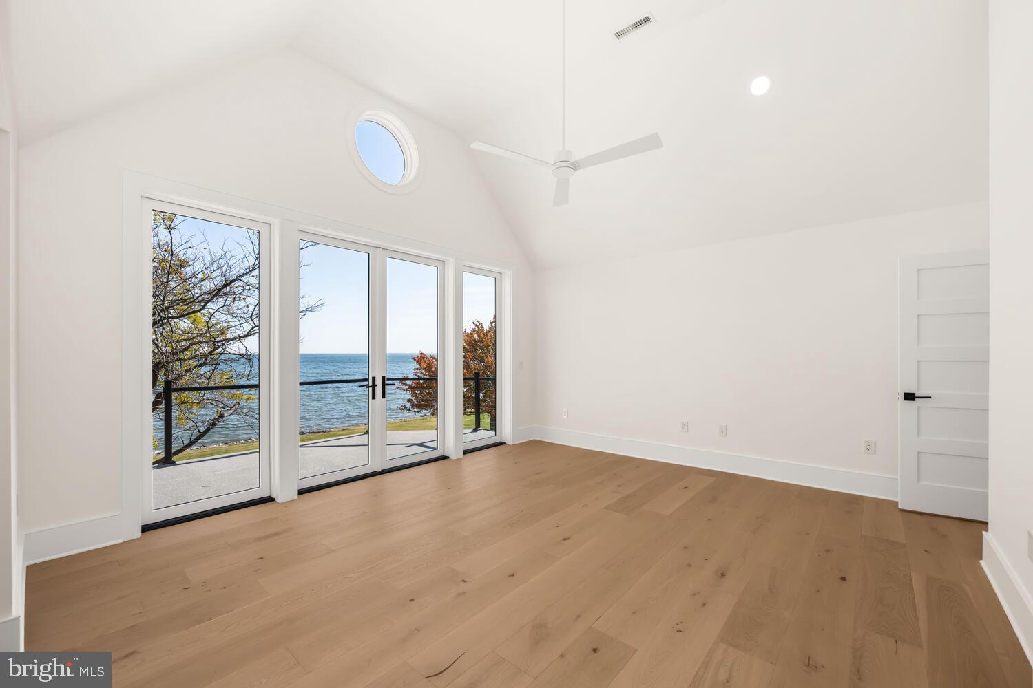 21485 Island Club Road Tilghman, MD 21671 - Photo 50 of 83 an empty room with wooden floor and windows