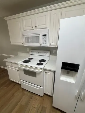 a kitchen with a sink and a stove with wooden floor