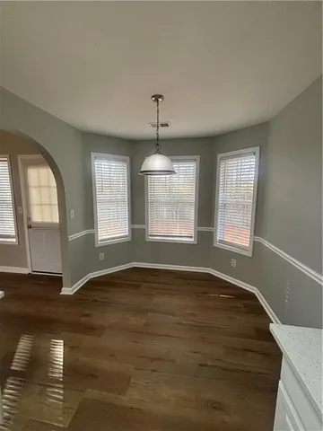 a large white kitchen with cabinets and wooden floor