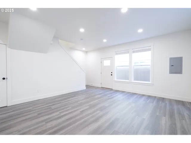 a view of an empty room with wooden floor