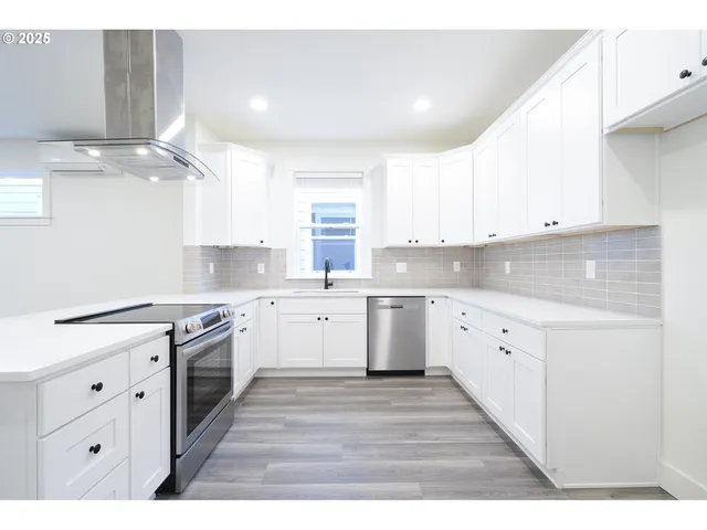 a kitchen with granite countertop a stove top oven sink and cabinets