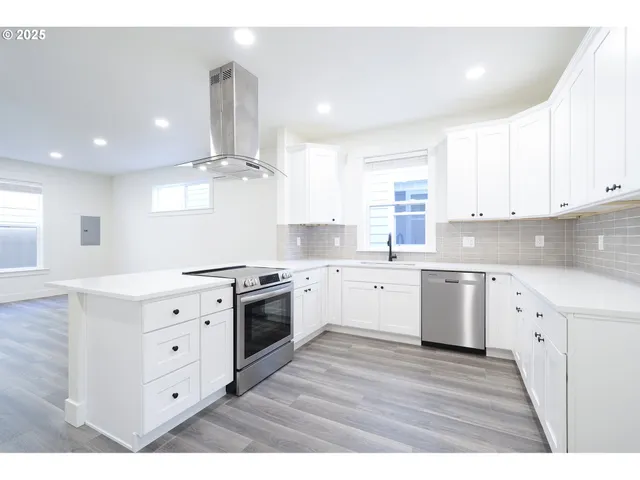 a kitchen with granite countertop a sink cabinets stainless steel appliances and a counter top space