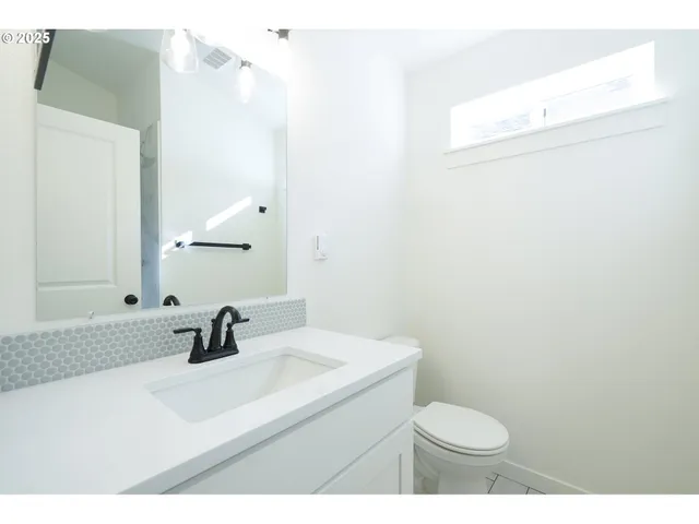a bathroom with a sink a toilet and mirror