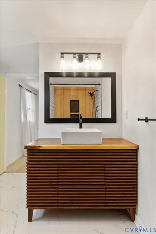 a bedroom with a bed table chair and glass door