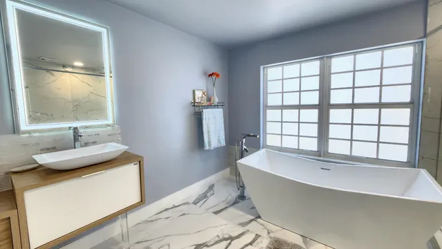 a bathroom with a sink a mirror and a window