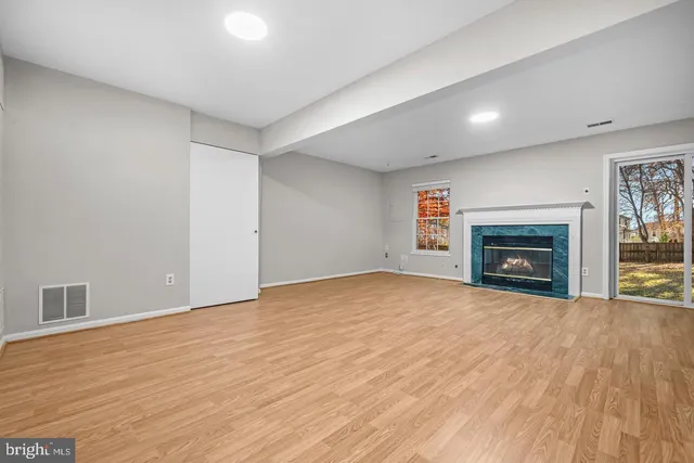 a view of an empty room with a window and fireplace
