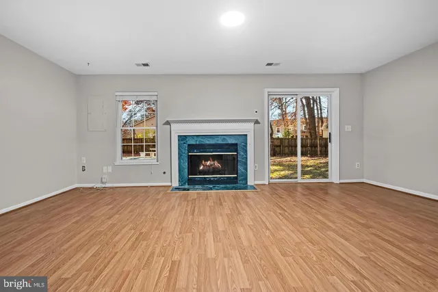 a view of empty room with a fireplace and wooden floor