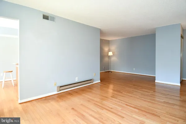 a view of an empty room with wooden floor