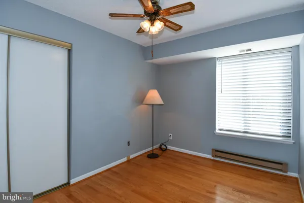 a view of an empty room with window and chandelier fan