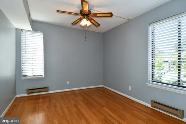 a view of an empty room with window and wooden floor