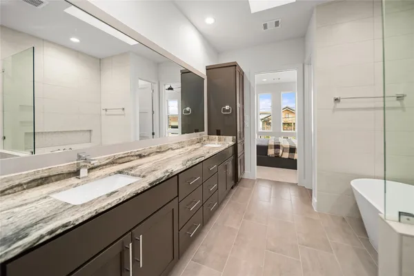 a bathroom with a granite countertop double vanity sink and mirror