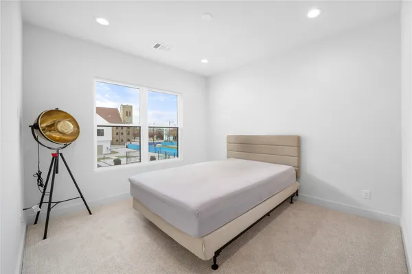a bed sitting in a spacious bedroom next to a window