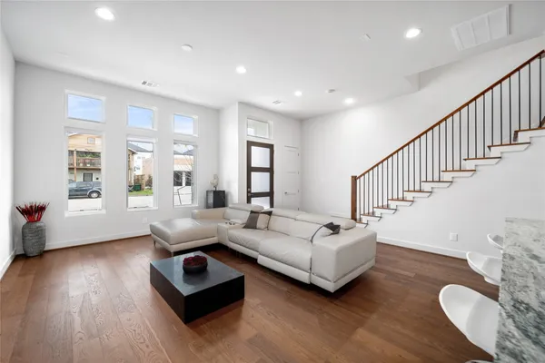 a living room with furniture and a wooden floor