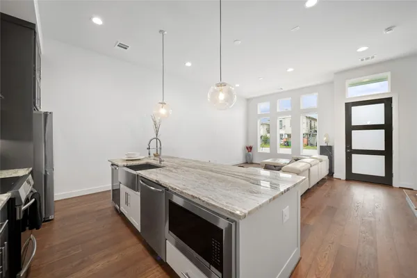 a kitchen with a stove and a wooden floor