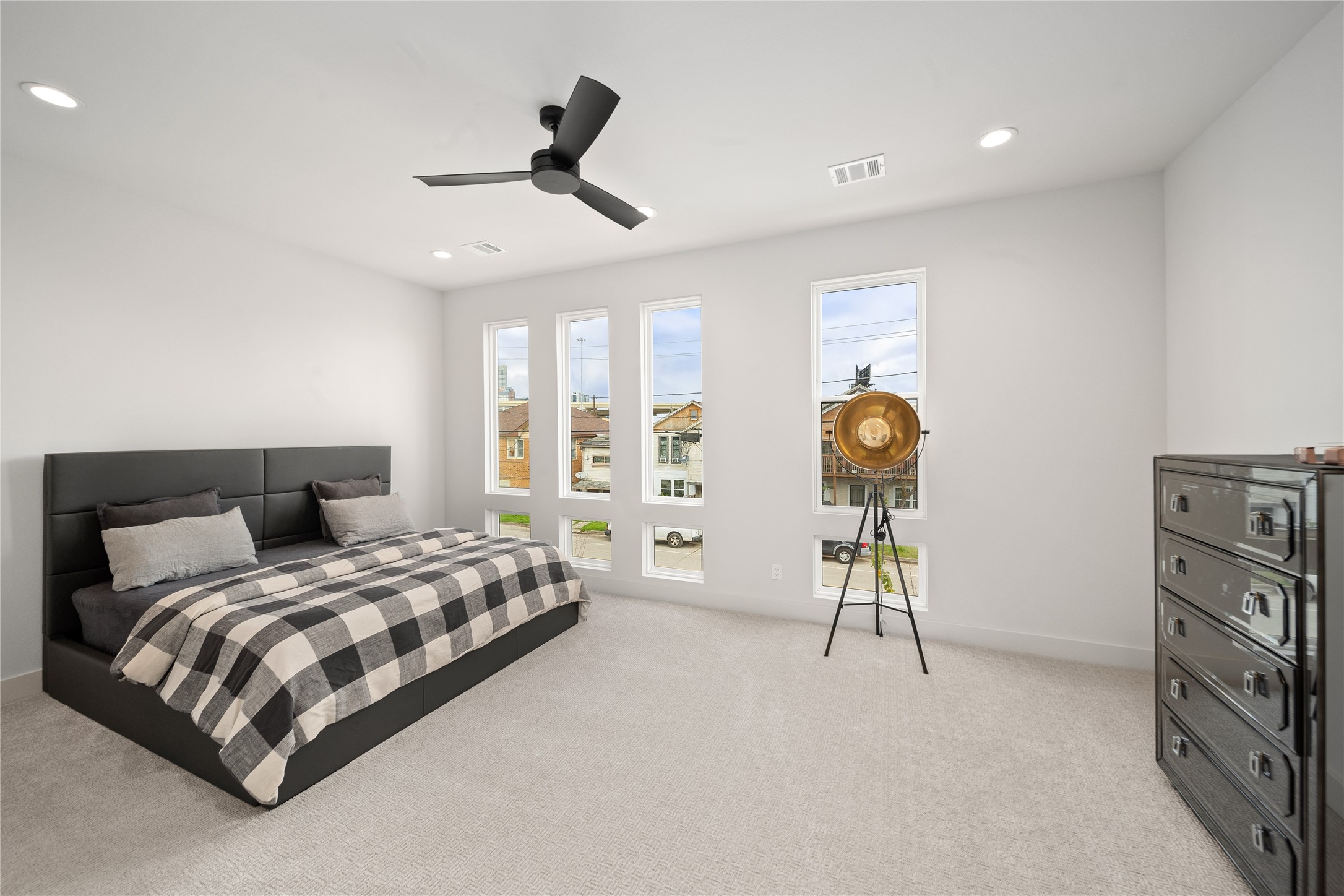 2408 Gray Street Houston, TX 77003 - Photo 9 of 23 a bedroom with a bed a dresser and a chandelier