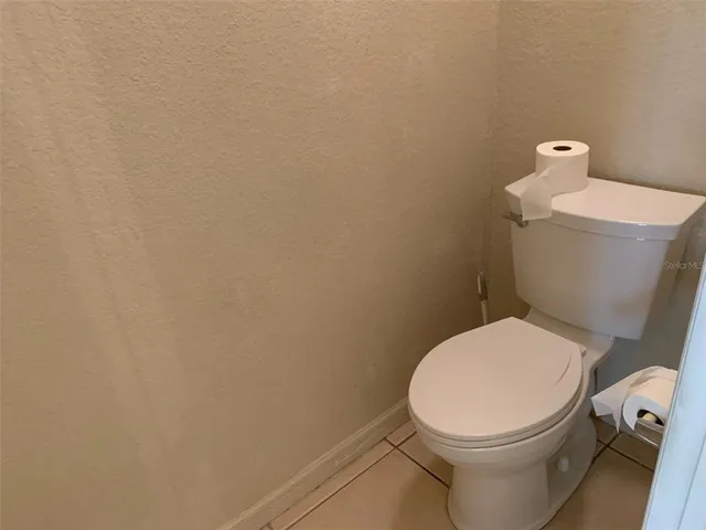 a white toilet sitting next to a white wall