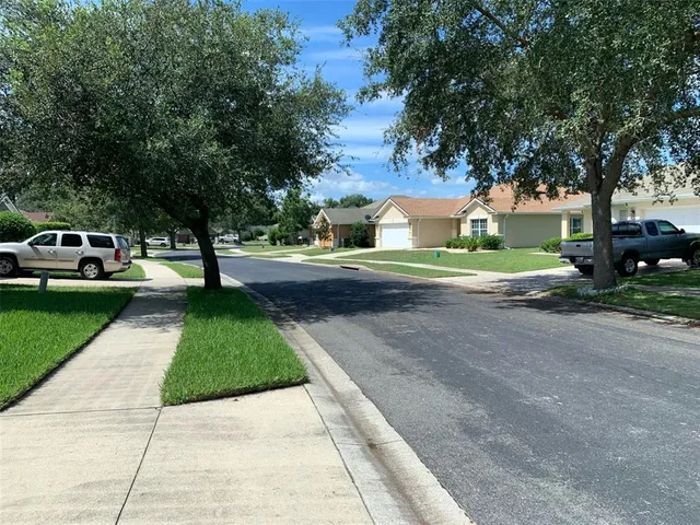 a front view of a house with a yard and trees