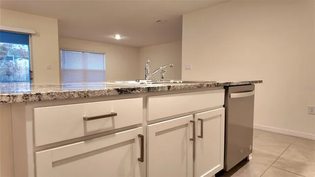 a large white kitchen with stainless steel appliances granite countertop a sink and cabinets