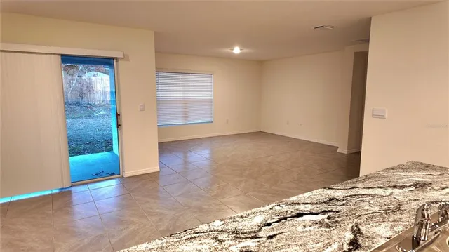 an empty room with entrance and windows