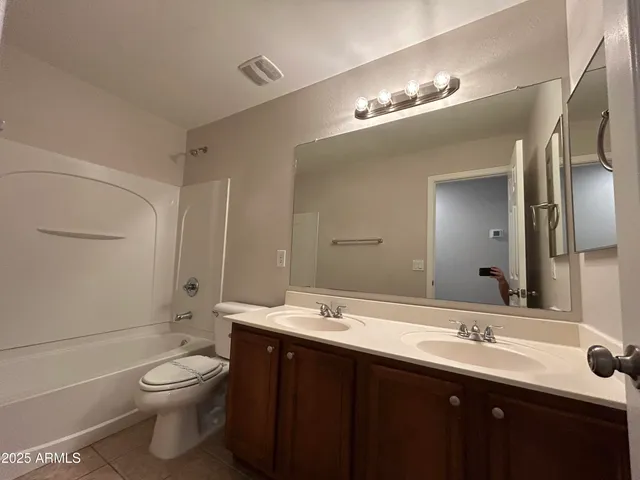 a bathroom with a double vanity sink toilet and a mirror