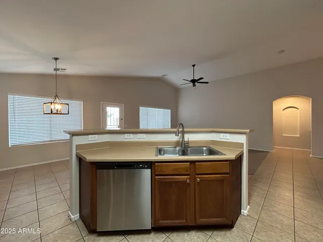 a kitchen with kitchen island granite countertop a sink cabinets and window
