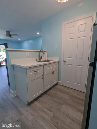 a room with a sink a mirror and cabinets