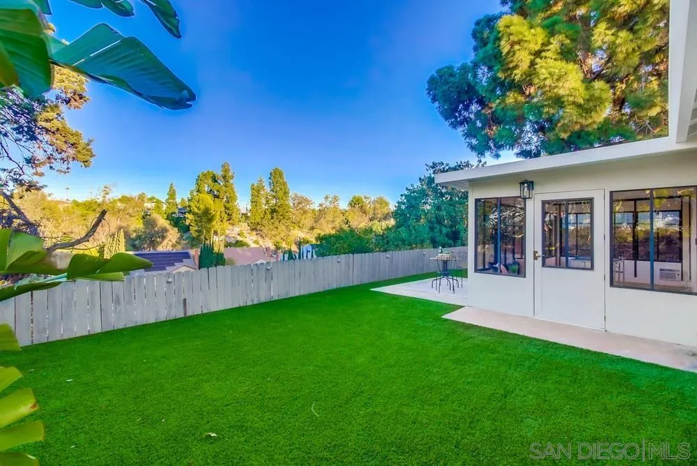 4793 54th Street San Diego, CA 92115 - Photo 54 of 74 a view of a backyard with plants and wooden fence