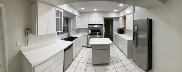a kitchen with stainless steel appliances a refrigerator and a stove top oven