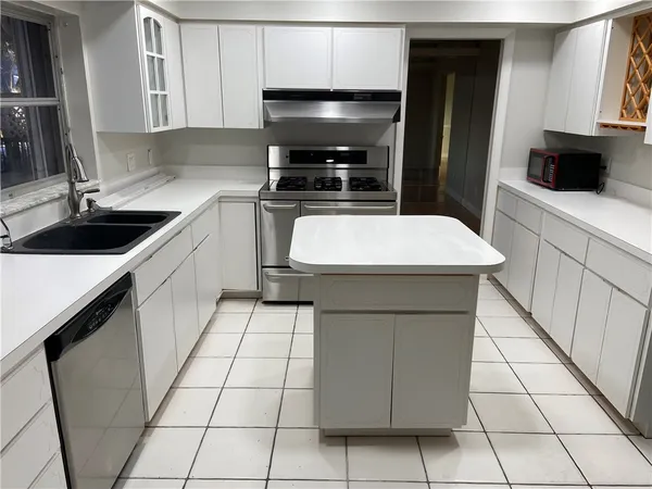 a kitchen with a sink a stove and cabinets