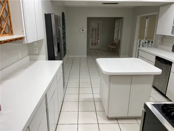 a room with a sink a refrigerator and cabinets