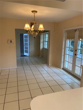 a view of a livingroom with a chandelier fan and windows