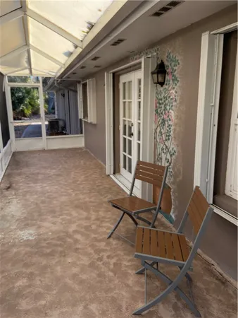 a view of a porch with furniture and front door
