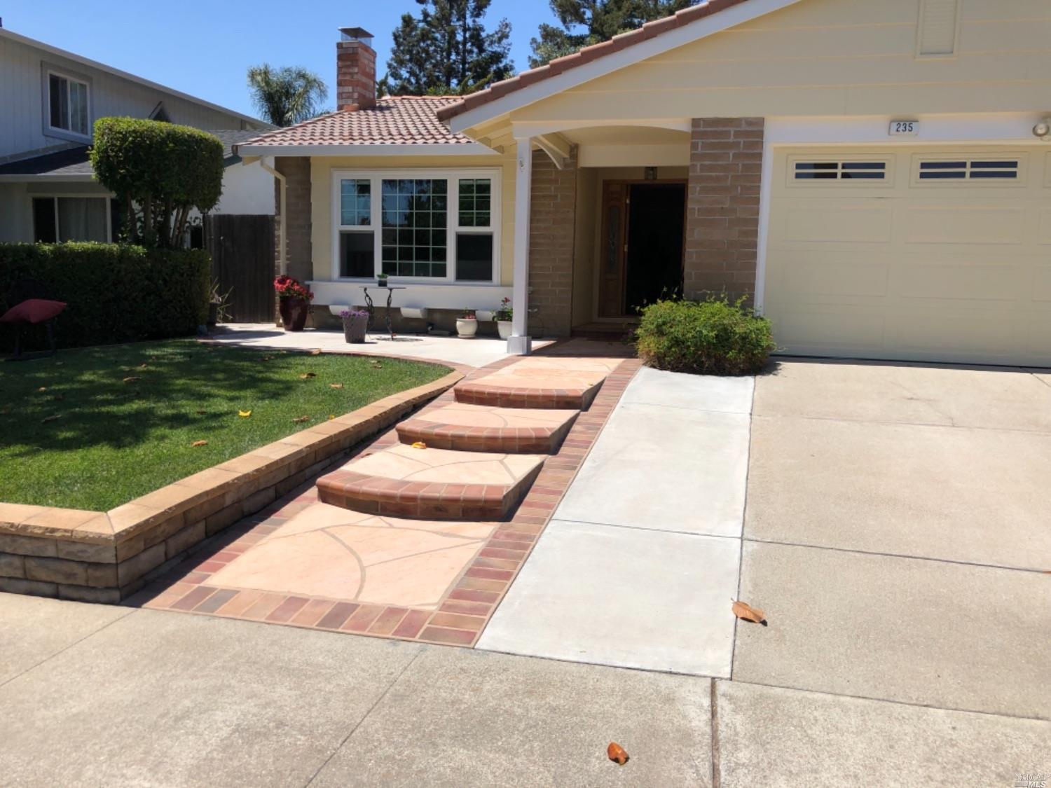 a view of a house with backyard and sitting area
