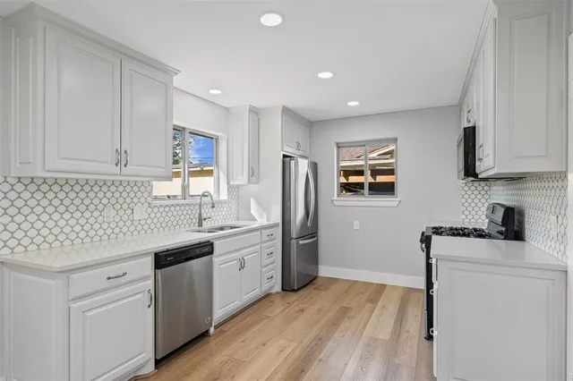 a kitchen with stainless steel appliances granite countertop a refrigerator sink and cabinets