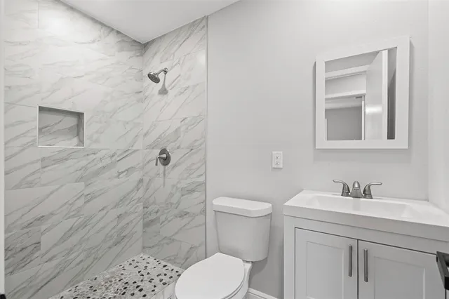 a bathroom with a sink a toilet and shower