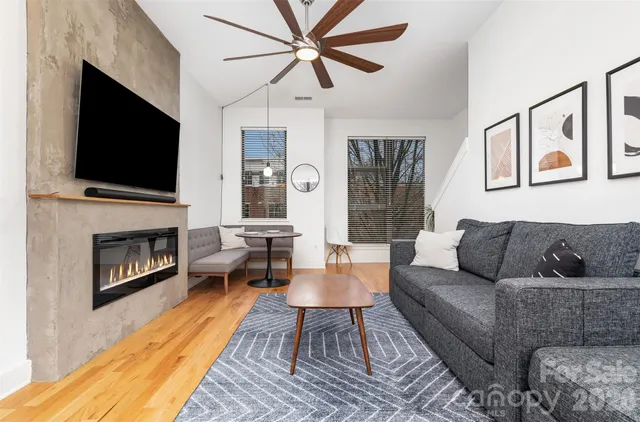a living room with furniture a flat screen tv and a fireplace