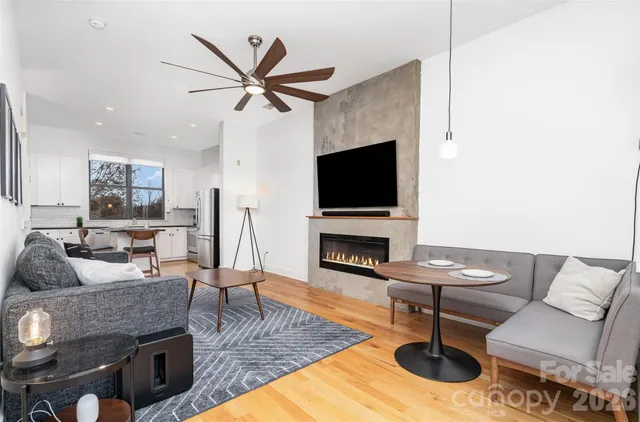 a living room with furniture a fireplace and a flat screen tv