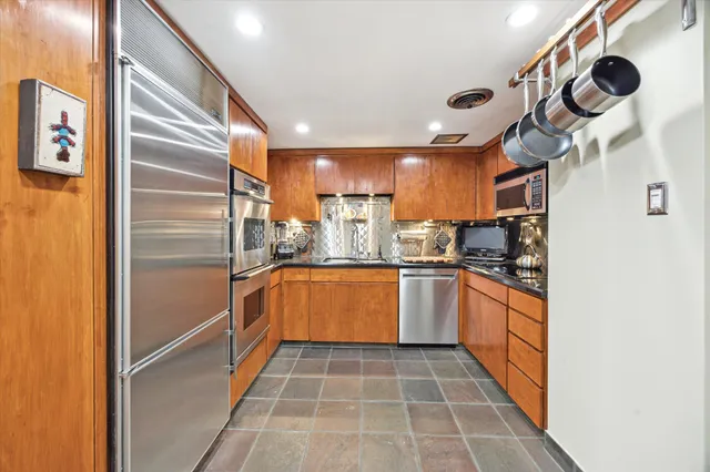 a kitchen with granite countertop stainless steel appliances a sink and cabinets