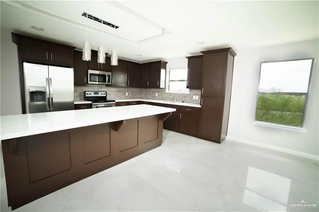 a kitchen with stainless steel appliances a sink stove and refrigerator